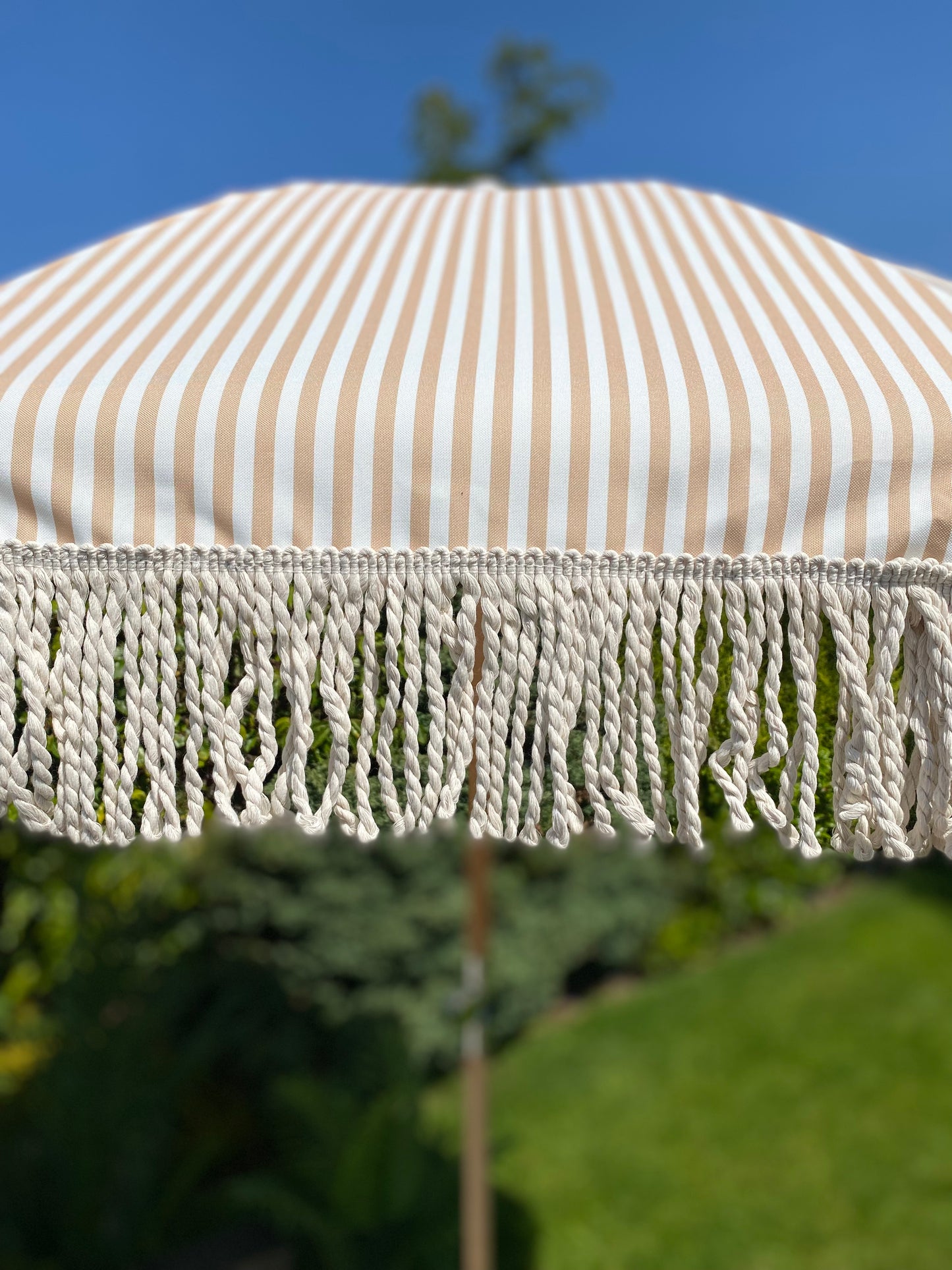 close up image of beige and white large sun parasol umbrella