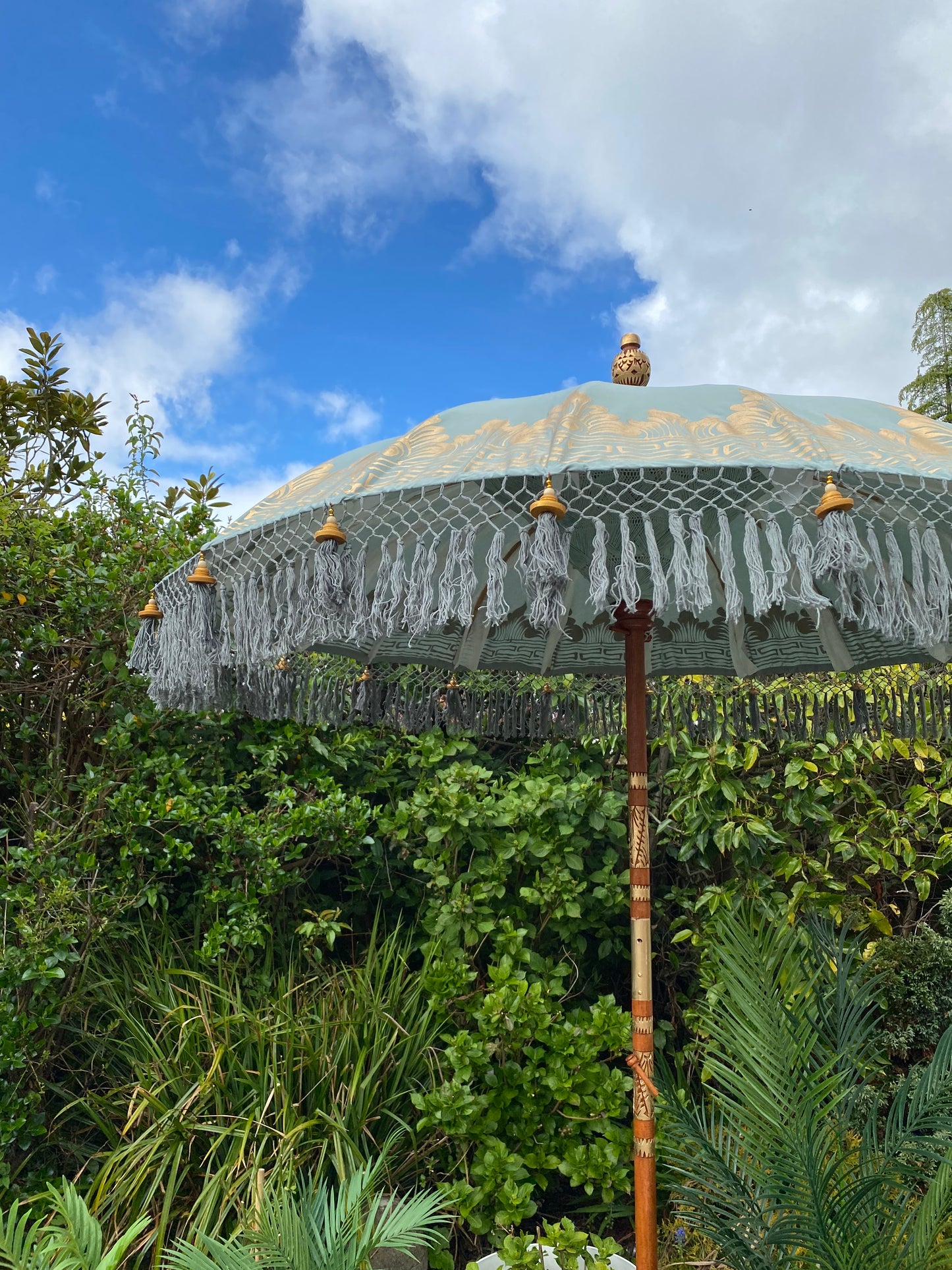 sage green and gold bali parasol umbrella close up image