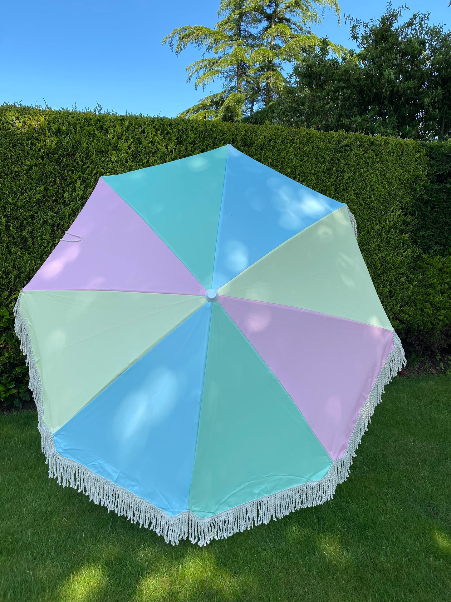 pastel pink blue green and yellow close up image of parasol canopy